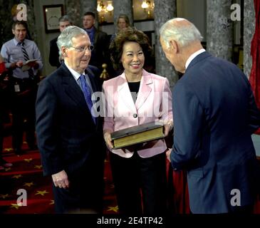 Washington DC, USA, 6. Januar 2015 Senator Mitch McConnell (R-KY) und seine Frau, ehemalige Arbeitsministerin Elaine Chao, halten die Familienbibel, während Vizepräsident Joe Biden (D) McConnell den Amtseid abgibt Stockfoto