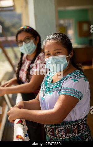 Junge Frauen mit schützenden Gesichtsmasken in San Juan la Laguna, Guatemala, Mittelamerika. Stockfoto