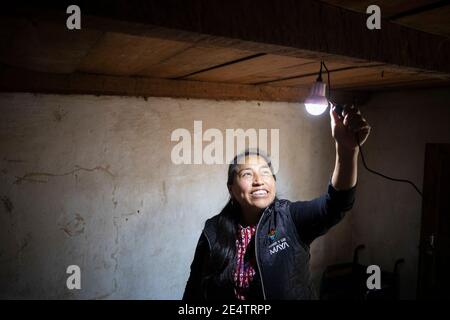 Ein Techniker von einem lokalen gemeinnützigen Energieversorger testet ein neues solarbetriebenes Beleuchtungssystem in einem Haus in Cantel, Guatemala, Centr Stockfoto