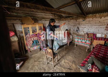 Ein Techniker von einem lokalen gemeinnützigen Energieversorger installiert ein neues solarbetriebenes Beleuchtungssystem in einem Haus in Cantel, Guatemala. Stockfoto