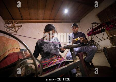 Familie, die ein neues solarbetriebenes Beleuchtungssystem in ihrem Zuhause in Cantel, Guatemala, Mittelamerika, verwendet. Stockfoto