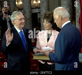 Washington DC, USA, 6. Januar 2015Senator Mitch McConnell (R-KY) und seine Frau ehemalige Arbeitsministerin Elaine Chao halten die Familienbibel, während Vizepräsident Joe Biden (D) den Amtseid an McConnell verwaltet.Kredit: Mark Reinstein / MediaPunch Stockfoto