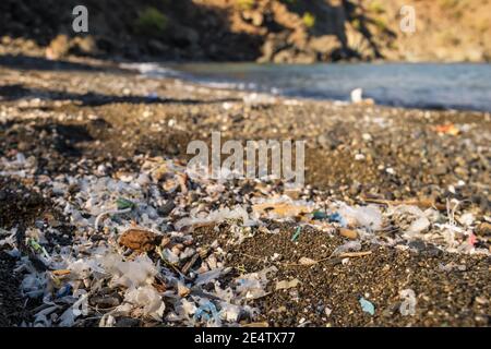 Kleine Kunststoffteile und Mikroplastik am Sandstrand Stockfoto