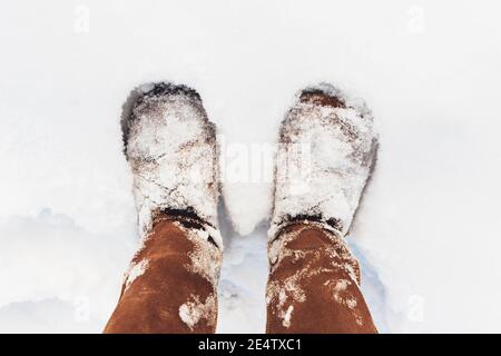 Braune Stiefel im Winter mit Schnee bedeckt Stockfoto