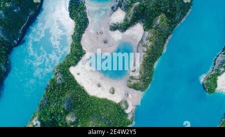 Luftaufnahme von oben auf Love Lagoon Karwapop mit türkisfarbenem Wasser in Herzform innerhalb der felsigen tropischen Insel auf Raja Ampat, Papua, Indonesien. Stockfoto