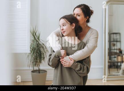 Portrait der Mutter mittleren Alters Frau und Tochter Teenager zusammen In hellem Innenraum Stockfoto