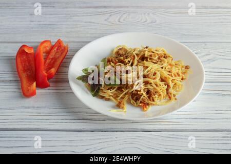 Teller mit Vermicelli gebraten mit Hackfleisch und gehacktem Gemüse Stockfoto