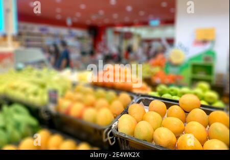 Abstrakte Blur im Supermarkt mit Orangen und Vielfalt an Früchten. Lebensmitteleinkaufkonzept. Stockfoto