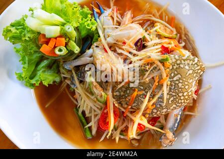 Thai Essen, Papaya Salat mit blauen Krabben auf einem weißen Teller, Papaya Salat mit Krabben Thai Essen Stockfoto