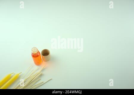 Orangenduft Öl in einer Flasche mit gelben Kerzen und Holzstäbchen auf dem Tisch. Aromatherapie, Spa, Massage, Entspannung oder Verbesserung der psychologischen. Stockfoto