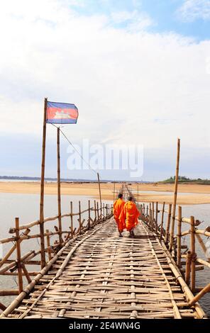 Zwei buddhistische Mönche auf Bambusbrücke über den Mekong Fluss zwischen Kampong Cham Stadt und Insel Koh Paen, Kambodscha Stockfoto