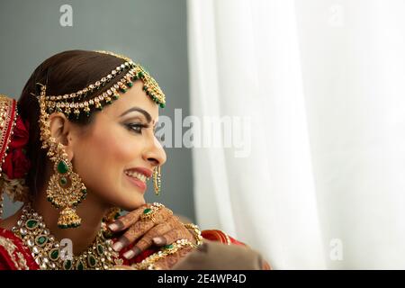 Indische Braut, die aus dem Fenster schaut Stockfoto