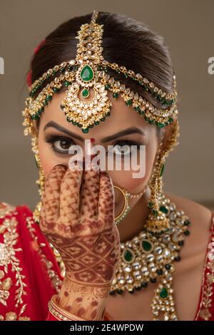 Schöne indische Braut, die einen Bindi auf die Stirn setzt Stockfoto