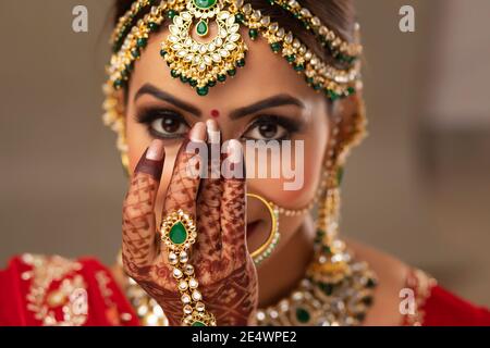 Schöne indische Braut, die einen Bindi auf die Stirn setzt Stockfoto