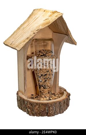 Selbstgemachtes Vogelfutterhäuschen aus Holz mit Glasflasche und Vogelsamen ich Stockfoto