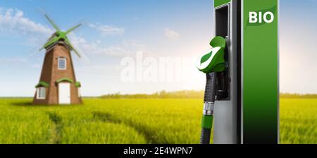 Biokraftstofftankstelle auf einem Hintergrund von Grünfeld mit Windmühle Stockfoto