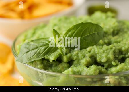 Glasschale mit Guacamole und Basilikum, Nahaufnahme Stockfoto