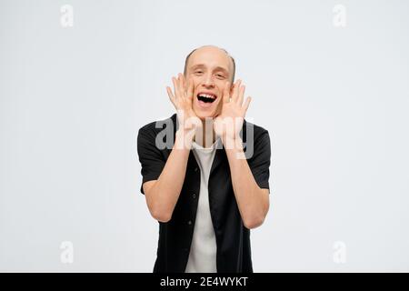 Schreiend, liefert Informationen junger Glatze Mann trägt schwarzes Hemd mit weißem T-Shirt darunter. Aufgeregt jungen Erwachsenen glücklich Mann zeigt Zufriedenheit Stockfoto