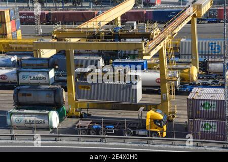 Blick auf einen großen Kran, der einen Container auf einen LKW im Containerhafen Barcelona lädt. Stockfoto