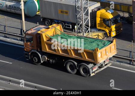 LKW mit einem Container voller Schutt. Stockfoto