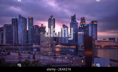 Singapur, 12. Februar 2020: Panorama der Uferpromenade Marina Bay Sand mit Wolkenkratzern des Finanzzentrums der Stadt am Abend mit illumina Stockfoto