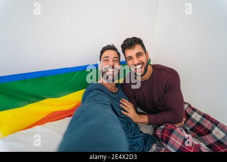 Glücklich Gay paar mit Spaß nehmen Selfie im Bett - Homosexuelle Liebe und Technologie Konzept Stockfoto