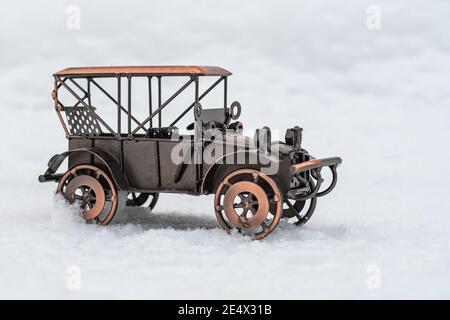 Bronze Modell Spielzeug Retro Auto steht auf weißem Schnee Stockfoto