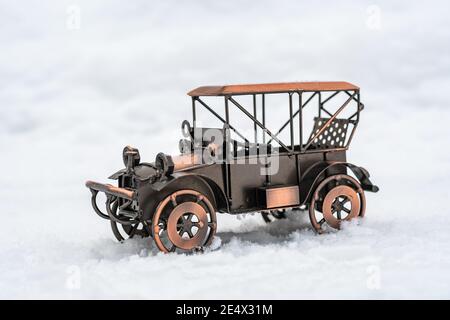 Bronze Modell Spielzeug Retro Auto steht auf weißem Schnee Stockfoto