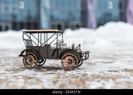 Bronze Modell Spielzeug Retro Auto steht auf einer Betonstraße Auf grauem Hintergrund Stockfoto