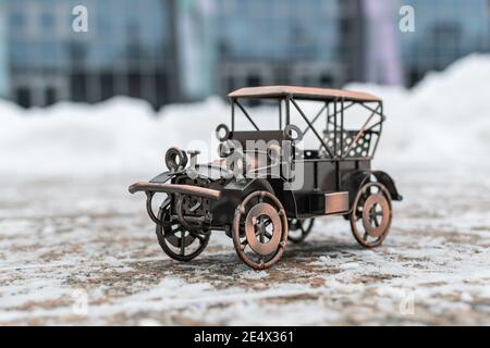 Bronze Modell Spielzeug Retro Auto steht auf einer Betonstraße Auf grauem Hintergrund Stockfoto