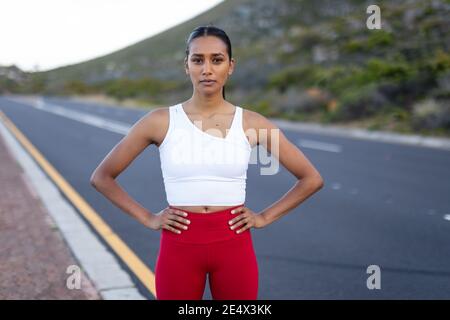 Porträt einer fitden afroamerikanischen Frau, die an einer Küste steht Die Straße schaut lächelnd auf die Kamera Stockfoto