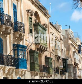Alter Palast mit traditionellen geschlossenen Holzbalkonen (Gallarija) in einer Straße von Valletta, Malta Stockfoto