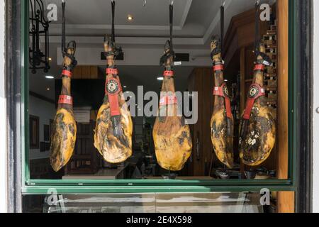 Spanische Schinken hängen an einem offenen Kaffeefenster, Cadaz, Spanien Stockfoto