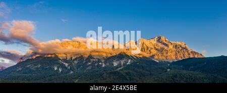 Panorama-Luftaufnahme der Alpenglow Zugspitze mit Nebel vom Eibsee see in Deutschland Sonnenuntergang Stockfoto