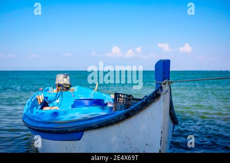 Bug eines kleinen hölzernen Fischerboot mit Seil gebunden schwimmend auf einer ruhigen Wasseroberfläche. Stockfoto