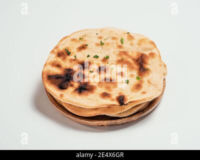 Frisches Naan Brot auf Teller isoliert auf weißem Hintergrund. Stapel von mehreren perfekten Naan Fladenbrot auf weiß. Stockfoto