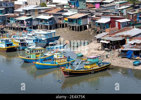 Phan Thiet, Provinz Binh Thuan, Vietnam - 15. Januar 2021: Fischerboote legen neben einem armen Fischerdorf in Phan Thiet, Provinz Binh Thuan an Stockfoto