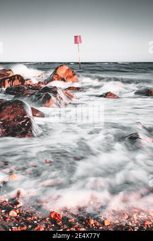 Wellen krachen über Felsen an einem felsigen Ufer Stockfoto