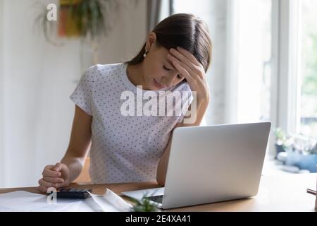 Besorgte junge Frau, die mit Finanzpapieren arbeitet, die Schulden herausfinden Stockfoto