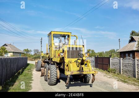 Straßengrader - Schwererde bewegende Straßenbauausrüstung. Industrieller Motorgrader auf dem Boden Stockfoto