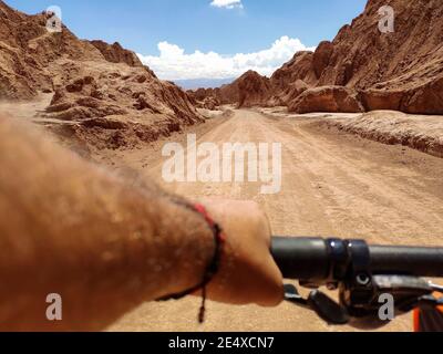 Crop unkenntlich Reisenden Fahrrad entlang sandiger Straße in Atacama fahren Wüste an sonnigen Tag Stockfoto