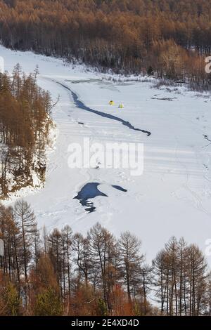 Fischerzelte auf dem Eis des Flusses Chulman in Südjakutien, Russland. Blick von oben. Stockfoto