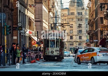 Typische Ansicht der Straße mit Menschen und Stadtstraße mit Autos und alten historischen Straßenbahn in Mailand, Italien. Stockfoto