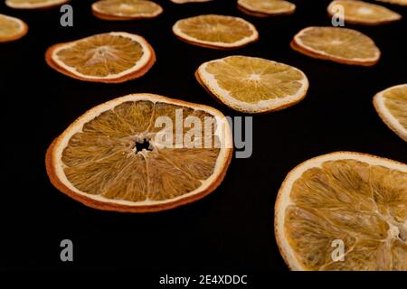 Muster mit getrockneten Orangen Früchte auf schwarzem Hintergrund. Stockfoto