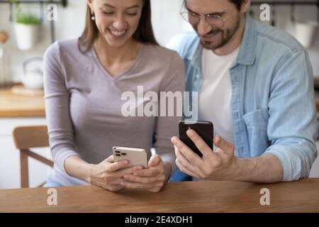 Junger Mann und Frau mit Mobiltelefonen, die Daten über WLAN teilen Stockfoto