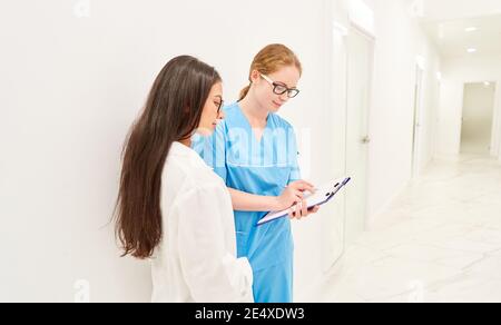 Ärztin und Krankenschwester mit Klemmbrett im Krankenhaus zusammenarbeiten Stockfoto
