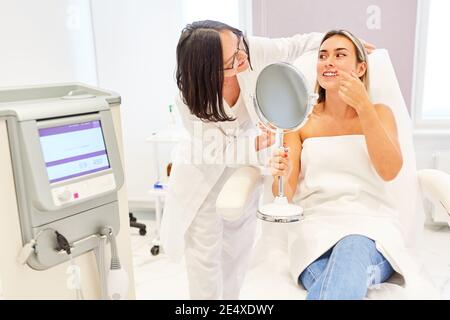 Patient und Arzt geben Beratung vor der Behandlung oder Facelift in Die Praxis des Dermatologen Stockfoto