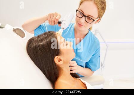 Frau während der professionellen Gesichtsreinigung im Kosmetikstudio mit Eine elektrische Bürste Stockfoto