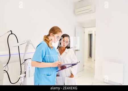 Arzt und ODER Krankenschwester mit Klemmbrett planen kosmetische Chirurgie Stockfoto