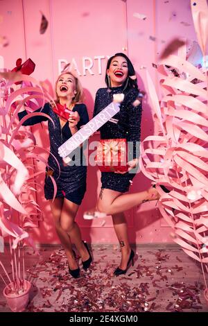 Fröhliche Damen halten Geschenkboxen in ihren Händen Stockfoto